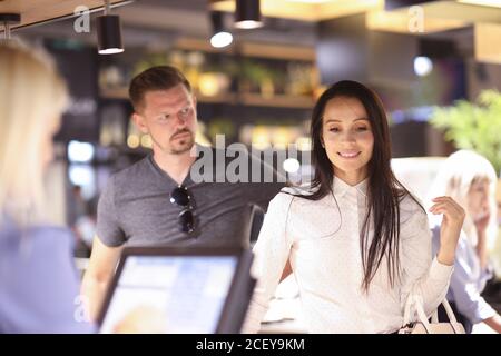 La femme pensive se tient près du terminal que l'homme la regarde surprise Banque D'Images