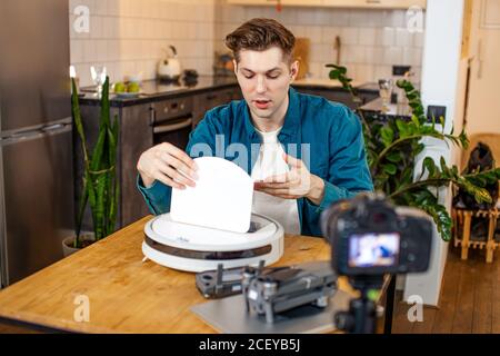 jeune homme de blogueur caucasien intéressé par les nouvelles technologies modernes, il montre comment utiliser un dispositif particulier, veulent être utile et intéressant pour audienc Banque D'Images