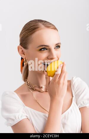 femme blonde rustique piquant jaune citron isolé sur blanc Banque D'Images