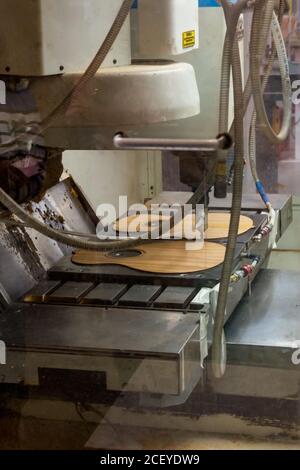 Une fraiseuse de précision CNC commandée par ordinateur coupe une guitare dans l'usine Taylor Guitar de Tecate, au Mexique. Banque D'Images