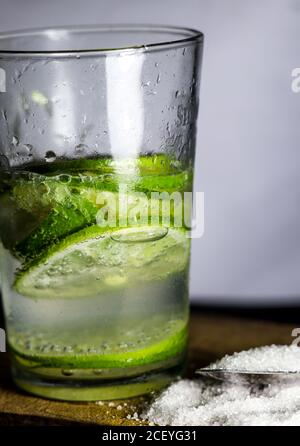 un verre de soda et de lime en tranches un arrière-plan blanc Banque D'Images