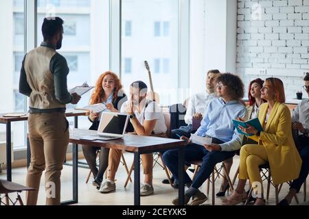 Un jeune coach d'affaires arabe fait une présentation à l'équipe des cadres dirigeants pour expliquer la stratégie dans les bureaux modernes, le responsable principal de l'entreprise présente emp Banque D'Images