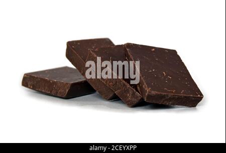 Cubes de lait et de chocolat noir. Pile de chocolat sur fond blanc. Pile de chocolat. Petits morceaux de chocolat noir. Banque D'Images