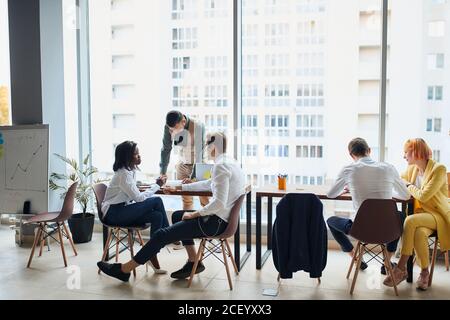 Cadres ayant une discussion amicale pendant la pause, des idées d'affaires, de construire la stratégie d'affaires tout en sititant sur table ensemble . arrière-plan de bureau Banque D'Images