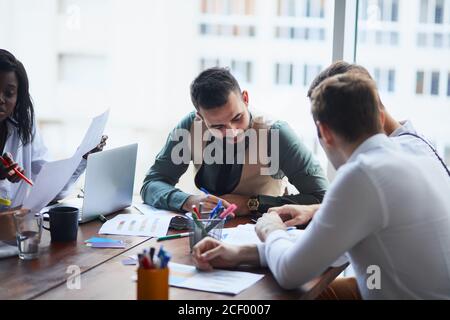 Cadres ayant une discussion amicale pendant la pause, des idées d'affaires, de construire la stratégie d'affaires tout en sititant sur table ensemble . arrière-plan de bureau Banque D'Images