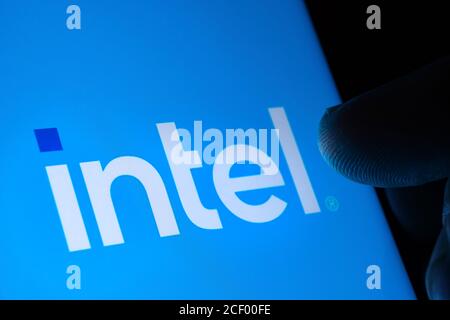 Nouveau logo Intel visible à l'écran et touche le bout du doigt dans l'obscurité. Intel a rebaptisé son logo. Sélectif Banque D'Images