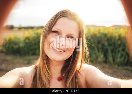 Portrait en gros plan d'une belle jeune femme avec une longue blonde cheveux prenant le selfie le jour ensoleillé Banque D'Images