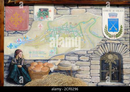 Peinture murale d'une jeune fille en costume de montagne traditionnel à côté d'un panier de pain frais et de fromage rond dans le petit village d'Usseaux, Piemon Banque D'Images