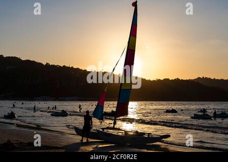 Location de bateau à voile sur la plage de Patong au coucher du soleil, Phuket, Thaïlande Banque D'Images