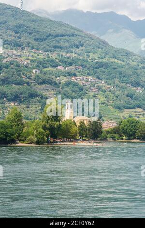 Paysage avec l'église catholique Santo Stefano à Dongo sur le lac de Côme. High Mountains et collines avec forêt. Banque D'Images