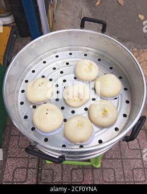 Boulettes de farine de riz traditionnelle vietnamienne cuites à la vapeur Banh Bao Tuoi pendant la cuisson. Vue de dessus. Cuisine de rue asiatique. Banque D'Images