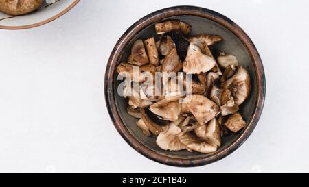 Les champignons frais, crus et hachés, se ferment dans un bol, reposent à plat avec un espace de copie Banque D'Images