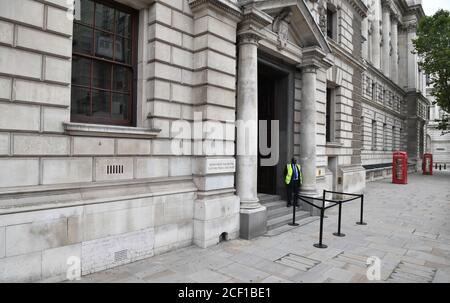 Un agent de sécurité regarde depuis l'entrée du Département du numérique, de la culture, des médias et du sport dans le Whitehall de Londres. Banque D'Images