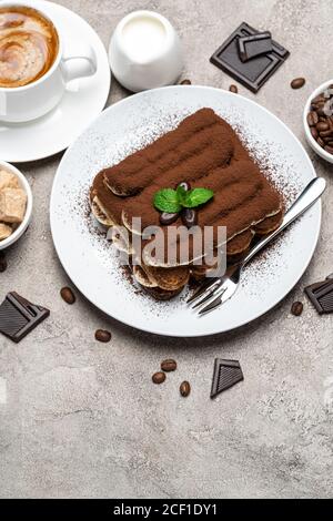 Dessert tiramisu classique, tasse de café, sucre et lait sur fond de béton Banque D'Images