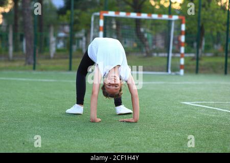 fille est engagée dans la gymnastique sur le terrain de sport. Banque D'Images