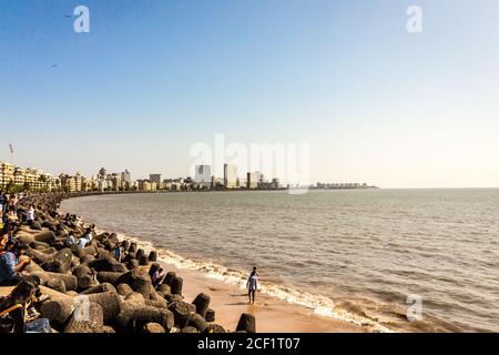 Promenade maritime avec les habitants de la région et les voyageurs qui profitent du soleil se baignant à la plage de Chowpatty. Marine Drive alias le collier de la Reine. Mumbai ville Marine. Banque D'Images