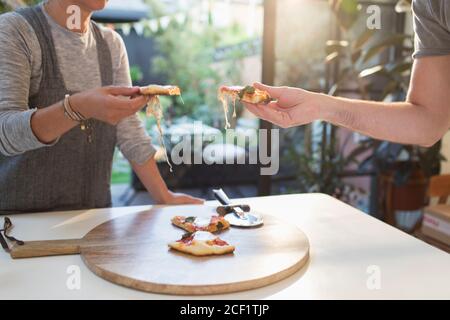Couple des pizzas à table à manger Banque D'Images