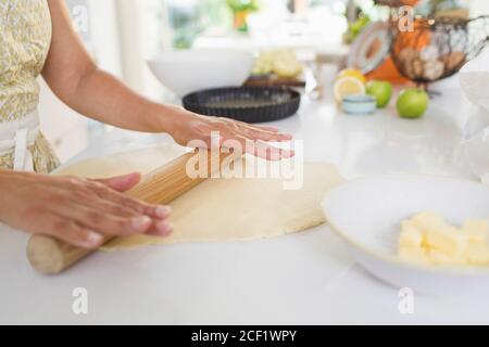 Femme roulant de la pâte à tarte avec la broche sur la cuisine compteur Banque D'Images