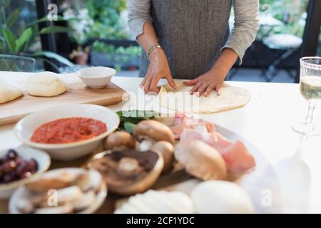 Femme qui fait de la pizza maison dans la cuisine Banque D'Images