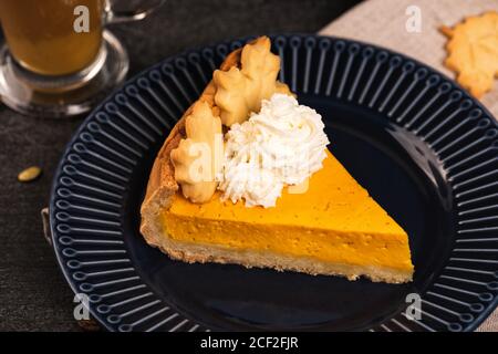 Tranche de tarte à la citrouille sur une assiette bleu foncé Banque D'Images