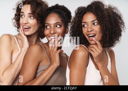 Portrait de trois femmes multiethniques émerveillement souriant et regardant de côté isolé sur fond blanc Banque D'Images