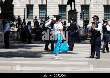 Une femme parle à un policier parmi une foule d'officiers à la suite d'une manifestation sur la place du Parlement, à Londres Banque D'Images