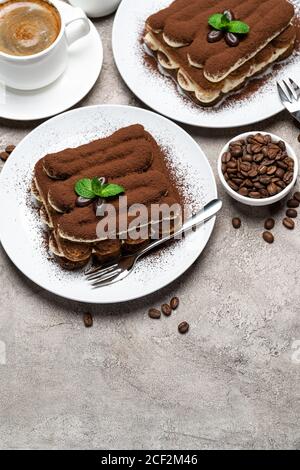 Dessert tiramisu classique, tasse de café, sucre et lait sur fond de béton Banque D'Images