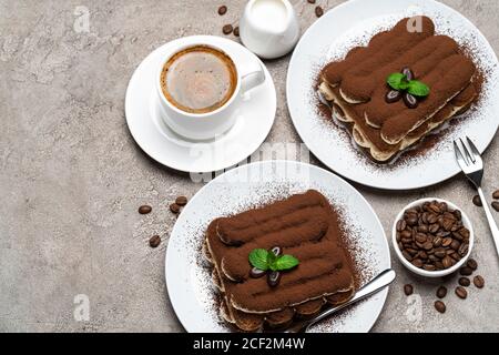 Dessert tiramisu classique, tasse de café, sucre et lait sur fond de béton Banque D'Images