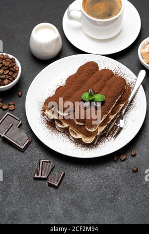 Dessert tiramisu classique, tasse de café, sucre et lait sur fond de béton Banque D'Images