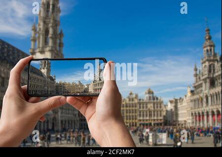 Tourisme prendre une photo de la Grand place (Grote Markt) à Bruxelles, Belgique. Homme tenant le téléphone et prenant des photos. Banque D'Images