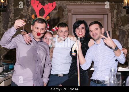 2019, décembre, Slovaquie. Fête du nouvel an avec des personnes masquées. .un jeune groupe heureux célébrant le nouvel an et buvant du champagne sur la fête de la mascarade Banque D'Images