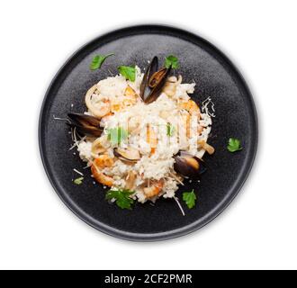 Délicieux risotto aux fruits de mer avec crevettes, crevettes et moules. Habillé de parmesan et de persil. Vue de dessus plat posé isolé sur blanc Banque D'Images