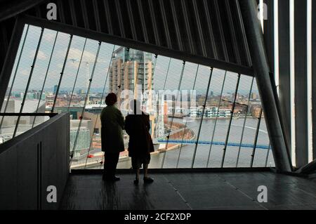 Deux personnes qui regardent Salford Quays depuis la tour d'observation (Air Shard) du Musée impérial de la guerre du Nord, Salford Quays, Manchester, Royaume-Uni. Banque D'Images