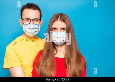 Photo en gros plan d'un couple amoureux romantique portant un masque facial protecteur, concept de pandémie et de sentiments, allergie. Personnes dans des masques médicaux. Auto-isolation Banque D'Images