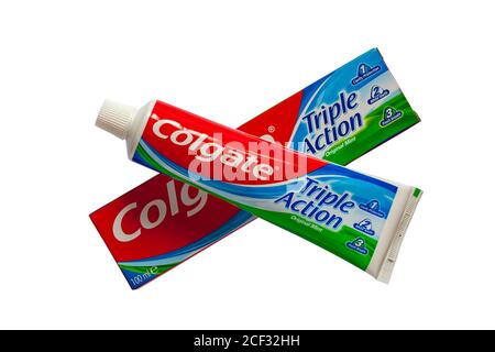 Tube de Colgate Triple action dentifrice original à la menthe hors de la boîte isolé sur fond blanc - 1 protection de cavité, 2 dents blanches, 3 souffle frais Banque D'Images