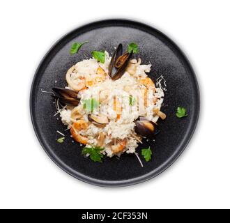 Délicieux risotto aux fruits de mer avec crevettes, crevettes et moules. Habillé de parmesan et de persil. Vue de dessus plat posé isolé sur blanc Banque D'Images