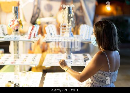 femme achetant un bracelet dans la boutique de plage Banque D'Images