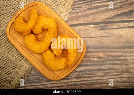 Crevettes de l'Atlantique frites dans de la pâte sur un plateau de service en bois. Gros plan Banque D'Images