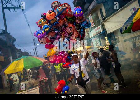 Un marchand de ballons afro-colombiens se promène dans la rue pendant le festival San Pacho à Quibdó, en Colombie. Banque D'Images