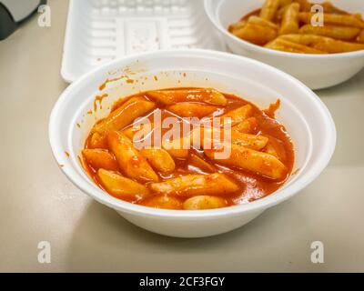 Tteok-bokki ou gâteaux de riz frits par Stir. Cuisine populaire de rue coréenne à base de gâteaux de riz et de poisson. Assaisonné de gochujang épicé, pâte de Chili. Banque D'Images