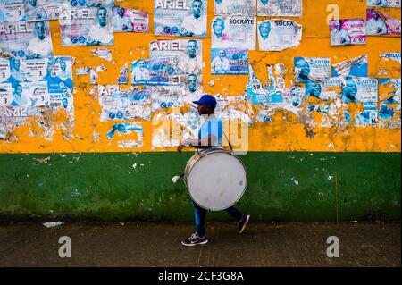 Un joueur afro-colombien de tambour du quartier de Pandeyuca marche devant le mur pendant le festival San Pacho à Quibdó, Colombie. Banque D'Images