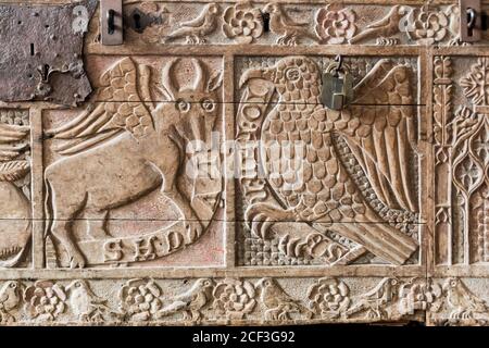 C14ème coffre en bois sculpté dans l'église Dersingham St Nicholas Norfolk montrant les symboles des évangélistes St Luke et St John. Banque D'Images