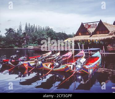 Thaïlande, Kanchanaburi. Bateaux touristiques et restaurants au tristement célèbre pont sur la rivière Kwai sur le chemin de fer de la mort Birmanie-Siam de la Seconde Guerre mondiale construit plus ou moins par les prisonniers de guerre alliés et la presse a ganté les personnes locales chargées de construire la voie de chemin de fer terrestre de Bangkok dans le golfe de Thaïlande À Rangoon en Birmanie dans le cadre du plan stratégique de l'armée impériale japonaise pour envahir l'Inde. Banque D'Images