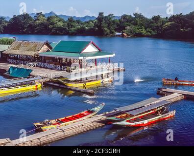 Thaïlande, Kanchanaburi. Bateaux touristiques et restaurants au tristement célèbre pont sur la rivière Kwai sur le chemin de fer de la mort Birmanie-Siam de la Seconde Guerre mondiale construit plus ou moins par les prisonniers de guerre alliés et la presse a ganté les personnes locales chargées de construire la voie de chemin de fer terrestre de Bangkok dans le golfe de Thaïlande À Rangoon en Birmanie dans le cadre du plan stratégique de l'armée impériale japonaise pour envahir l'Inde. Banque D'Images