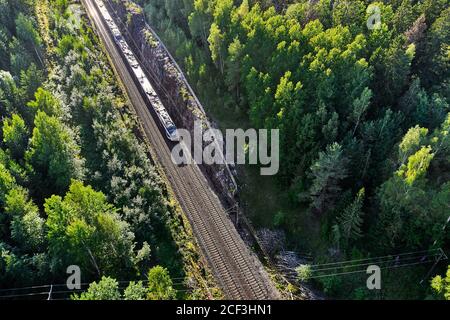 Le train de banlieue à grande vitesse se déplace sur le chemin de fer dans la campagne à Espoo, en Finlande. Vue aérienne. Banque D'Images