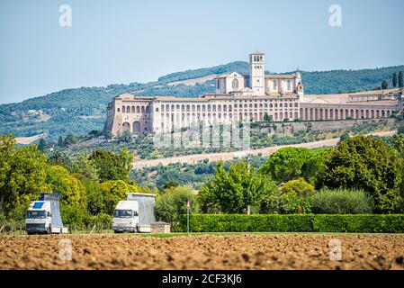 Camions sur la route et village ville d'Assise en Ombrie, Italie paysage urbain de l'église pendant la journée d'été ferme paysage rural dans la campagne étrusque Banque D'Images