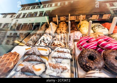 Assortiment variété de nombreux beignets à glaçage au sucre rose chocolat avec Dessert cannoli traditionnel exposé dans la boulangerie en Italie Banque D'Images