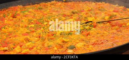 Paella fraîchement préparée dans une grande casserole ouverte. Banque D'Images