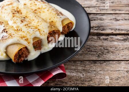 Délicieuses pâtes de cannelloni à la viande sur une table en bois Banque D'Images