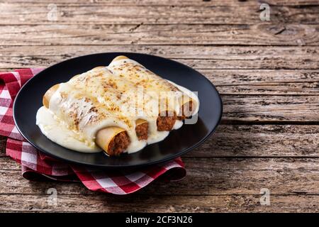 Délicieuses pâtes de cannelloni à la viande sur une table en bois Banque D'Images